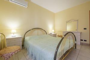 サンタレッシオ・シークロにあるCasa a 100 mt Dal Mareのベッドルーム1室(ベッド1台、テーブル2台、鏡付)