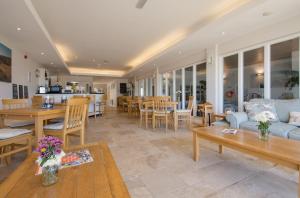 - un salon avec un canapé, des tables et des chaises dans l'établissement 24 Burgh Island Causeway, à Bigbury on Sea