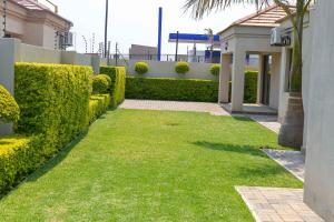 a yard with green grass next to a fence at Immaculate Villa in Gaborone