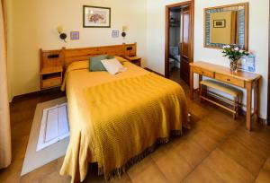 a bedroom with a bed and a table and a desk at Hotel Esther in La Virgen de la Vega