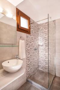 a bathroom with a sink and a glass shower at Green Studio in Kantouni in Kokkari