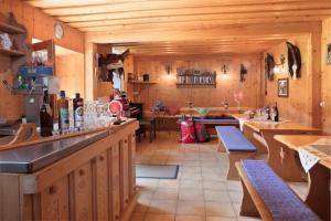 eine Küche mit Holzwänden und eine Bar mit Bänken in der Unterkunft Bayerwald-Ferienhof Schmid in Eppenschlag