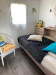 1 dormitorio con 1 cama, 1 silla y 1 ventana en Appartement à l’étage indépendant, en Ars-en-Ré