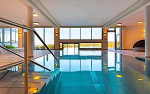 a swimming pool with blue water in a building at Familienhotel Petschnighof in Diex