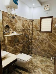 ein Bad mit einem WC und einem Waschbecken in der Unterkunft Hotel Whistling Greens in Moga