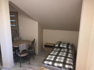 a room with a bed and a table and chairs at GOLENICKA PRZYSTAŃ in Golenice