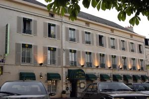 a large building with cars parked in front of it at Le Relais De La Poste in Pithiviers