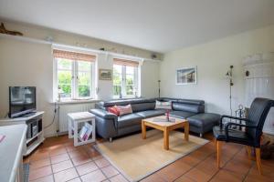 a living room with a couch and a table at Hardesweg 63 Nummer 1 in Wrixum