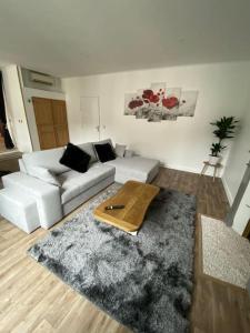 ein Wohnzimmer mit einer weißen Couch und einem Teppich in der Unterkunft L'Escale ZEN in Tulle