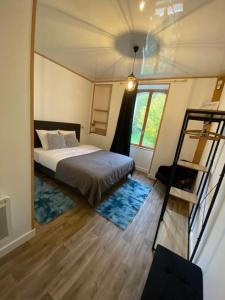 ein Schlafzimmer mit einem Bett, einer Treppe und einem Fenster in der Unterkunft L'Escale ZEN in Tulle
