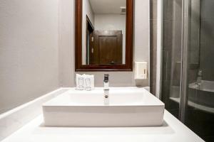 Un lavabo blanco en un baño con espejo. en Baan Sukhumvit Soi 20, en Bangkok 25 fotos más