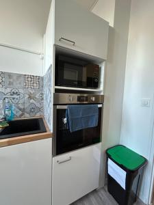 een kleine keuken met een magnetron en een wastafel bij Le Parmentier - 1 place de parking privative in Saint-Aignan