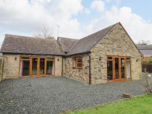 a detached stone house with a large driveway at The Stable in Craven Arms