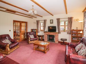 a living room with leather furniture and a fireplace at The Stable in Craven Arms