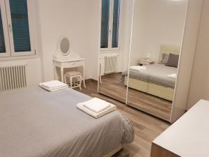 una piccola camera con due letti e uno specchio di memeapartments a Genova