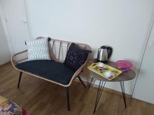 a wicker chair sitting next to a side table at LE SECHOIR DANTAN in Doudeville