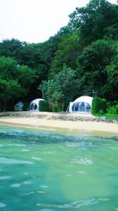 twee tenten op een strand naast het water bij Touch Glamping Koh Yao Noi ทัช แกรมปิ้ง เกาะยาวน้อย in Ko Yao Noi