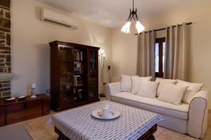 a living room with a white couch and a table at Zoe & Zen Collection in Kampos Paros