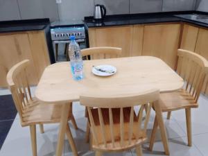 a bottle of water sitting on a wooden table in a kitchen at Résidence Rosalie in Yaoundé