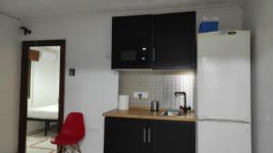 a kitchen with a refrigerator and a red chair at Convenient Rooms - Ferry, Train & Bus Station - in Algeciras