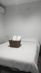 a basket of towels sitting on top of a bed at Convenient Rooms - Ferry, Train & Bus Station - in Algeciras
