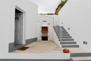 una casa blanca con escaleras y una calabaza en el suelo en Village House en Ribeira Grande