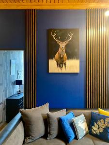 a living room with a couch and a painting of a deer at Apartament Górski 90m2 blisko centrum i wyciagu in Szklarska Poręba