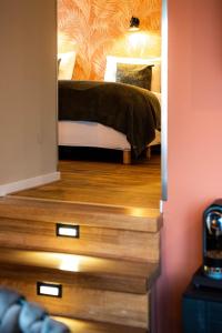 a bedroom with a bed in a room with wooden floors at Hotel Het Wapen van Drenthe in Roden