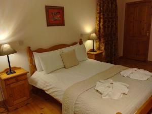 a bedroom with a bed with two towels on it at Kearneys Cottage, Dugort, Achill Island, County Mayo - 3 Bedroom Sleeps 6 in Bellanasally