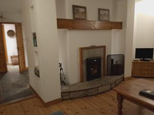 sala de estar con chimenea y TV en Kearneys Cottage, Dugort, Achill Island, County Mayo - 3 Bedroom Sleeps 6, en Bellanasally