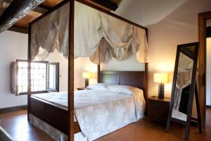 a bedroom with a canopy bed with a wooden frame at Ca' Marisa Aquileia in Aquil&eacute;ia