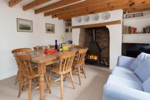 a dining room with a table and chairs and a fireplace at Westcott Cross Cottage, Luxborough in Luxborough