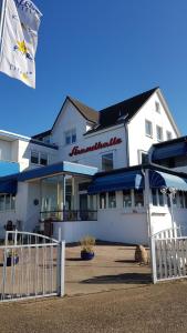 a building with a dog laying in front of it at Akzent Hotel Strandhalle in Schleswig