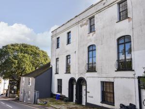 - un vieux bâtiment en briques blanches dans une rue dans l'établissement Flat 3, St Agnes House, à Lyme Regis