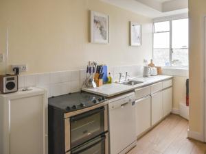 a kitchen with a sink and a stove top oven at Flat 3, St Agnes House in Lyme Regis