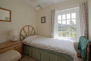 1 dormitorio con 2 camas y ventana en The Old Cart Shed in the Peak District, en Bakewell