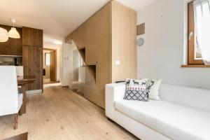 a living room with a white couch and a kitchen at Casa Ami in Sesto