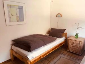 a bedroom with a bed with a night stand and a picture at Fischerhaus in Burgthann