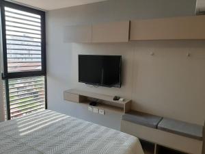sypialnia z łóżkiem i telewizorem z płaskim ekranem w obiekcie You Suite by INN w mieście Santa Cruz de la Sierra