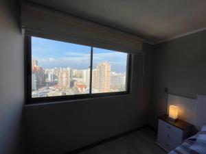 een slaapkamer met een raam met uitzicht op de stad bij Dpto 2D 1B, Parque Almagro, Santiago. in Santiago