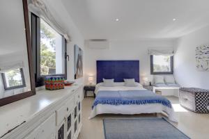 a white bedroom with a large bed and windows at Magical Ibizan Villa Walking Distance To The Beach Es Vedra Style 6 Bedrooms Fabulous Sea Views San Jose in Sant Josep de Sa Talaia +29 photos
