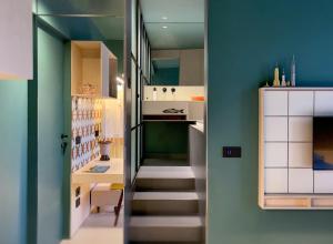 a stairway leading to a kitchen with green walls at Le stanze di Caterina in Cesenatico
