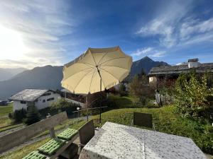 une table avec un parasol au-dessus d'un champ dans l'établissement Haus Maran, à Urmein