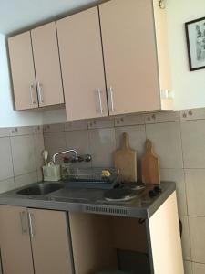 una cocina con armarios blancos y fregadero en Apartments Subotic, en Risan