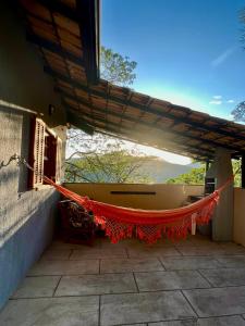 a hammock under a roof on a patio at Casa do Alto Santa Mônica- Natureza ao seu redor in Itaipava