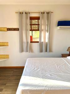 a bedroom with a bed and a window at Casa do Alto Santa Mônica- Natureza ao seu redor in Itaipava