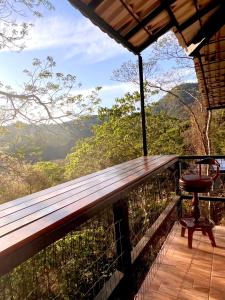 d'un balcon avec une chaise et une vue sur la forêt. dans l'établissement Casa do Alto Santa Mônica- Natureza ao seu redor, à Itaipava