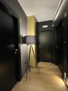 a hallway with black doors and a floor lamp at Plebiscito Boutique Rooms in Naples