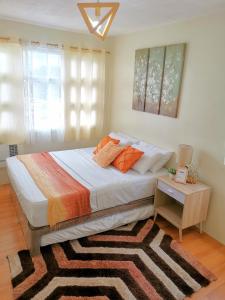 a bedroom with a bed with a rug and a table at Davao Condo 2BR Pool Wifi Netflix in Davao City