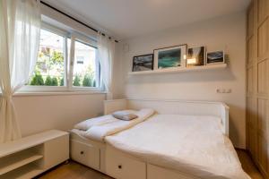 um pequeno quarto com uma cama e uma janela em Casa Fiammetta em Brunico